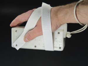 A Palm Writer being held in a right hand grip using the Ergonmic Grip Kit, showing wrist strap, Wrist Rest, Suspension Strap, and right plate