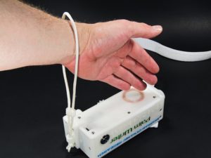 A hand inserted through an untightened wrist strap on a Palm Writer